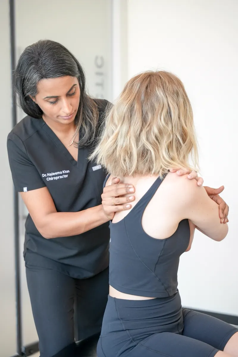 Dr. Haleema Khan checking how a patient's shoulder and upper back move